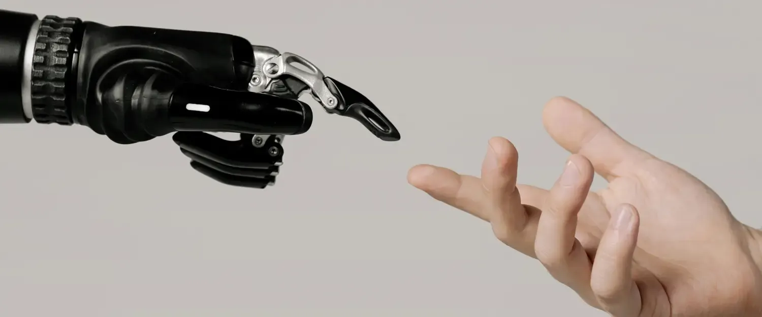 Photo of hands between human and robot as reference to the creation of Adam painting